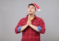 Young man in Santa hat praying