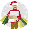 Young man in santa hat walking with shopping bags and boxes - christmas, sale, discount and holidays concept Royalty Free Stock Photo