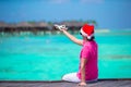 Young man in santa hat on white beach with miniature of airplane Royalty Free Stock Photo