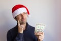 Young man with Santa red hat holding one dollar bills