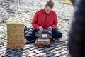Young man sat crossed legged with vintage typewriter offering to write a poem in Bristol, UK