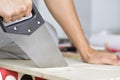 Young man sawing a wooden board with a handsaw Royalty Free Stock Photo