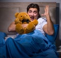 Young man scared in bed Royalty Free Stock Photo