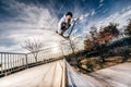 Young man with scooter making a jump on Skatepark during sunset Royalty Free Stock Photo