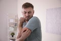 Young man scratching arm. Allergy symptoms Royalty Free Stock Photo