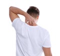 Young man scratching back on white background.