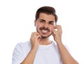 Young man scratching face on white background.