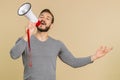 Young man scream shout in megaphone loudspeaker announces discounts sale, announcing advertisement Royalty Free Stock Photo