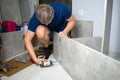 Man screwing boards with bolts using electric screwdriver collecting furniture, hands closeup. Assembling wooden case wardrobe on Royalty Free Stock Photo