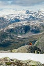 Young man seating on edge of mountain