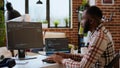 Young man seen programming software code on his laptop in a sleek home office Royalty Free Stock Photo