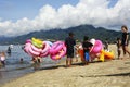 Young man sells and peddles ring lifebuoy on white sand beach