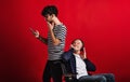 Young man and senior father in wheelchair in a studio, using technology. Royalty Free Stock Photo