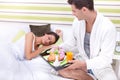 Young man serving breakfast for his girlfriend in bed