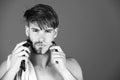 Young man shaving face hair with safety razor and electric shaver Royalty Free Stock Photo