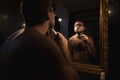 A man trims his beard in front of the mirror Royalty Free Stock Photo