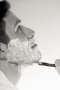 Young man shaving using razor with cream foam. Royalty Free Stock Photo