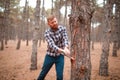 A man cuts a tree with an ax in a tree in an autumn forest Royalty Free Stock Photo