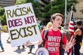 A Young White Man Holds a Sign that Says Racism Does Not Exist