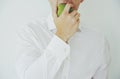 Young man in shirt taking biting a green apple Royalty Free Stock Photo