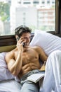 Young man shirtless on his bed with a coffee or tea cup Royalty Free Stock Photo