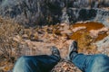 Young man shoes, leg with aerial view to swamped quarry with high dry grass, small pond, rock, Czech republic