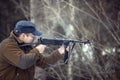 Young man shoots from a submachine gun Royalty Free Stock Photo