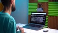 A young man shoots a video on a smartphone while reading text from a teleprompter on a laptop