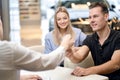 young man shop assistant explaining talking offering buying new car to family Royalty Free Stock Photo