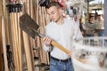 Young man choosing shovel in store Royalty Free Stock Photo