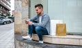 Young man with shopping bags sitting Royalty Free Stock Photo