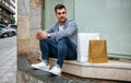 Young man with shopping bags sitting Royalty Free Stock Photo