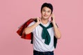 Young man with shopping bags talking on smart phone isolated on pink background Royalty Free Stock Photo