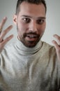 Young man with a short beard speaks gesturing with his hands to explain something Royalty Free Stock Photo