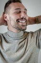 Young man with a short beard touches his head in a moment of relaxation Royalty Free Stock Photo