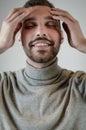 Young man with a short beard touches his temples in a moment of relaxation Royalty Free Stock Photo