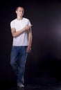 Young man with a short haircut in a white T-shirt and blue jean Royalty Free Stock Photo