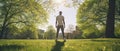 A young man shot from behind, starting exercising, workout in them middle of a park. Sunshine, trees around