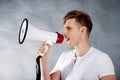 Young man shouting in megaphone.