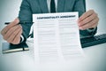 Young man showing a confidentiality agreement document