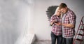 Young man showing design project on smartphone to focused woman indoors. Happy couple making interior apartment layout