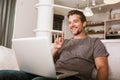 Man showing gesture in sign language, using laptop