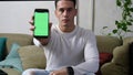 Young man showing his cell phone`s blank green screen Royalty Free Stock Photo