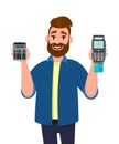 Young man showing or holding digital calculator device and POS terminal, credit, debit, ATM card swiping payment machine in hand. Royalty Free Stock Photo