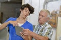Young man showing older man something on tablet