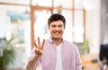 Young man showing three fingers over office room Royalty Free Stock Photo