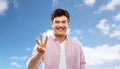 Young man showing three fingers over sky Royalty Free Stock Photo