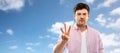 Young man showing three fingers over sky Royalty Free Stock Photo