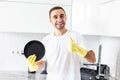 Young handsome Man showing thumbs up washing dishes in the kitchen Royalty Free Stock Photo