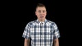 A young man shows an emotion of fear on his face. A person experiences fear. A man in a shirt on a black background Royalty Free Stock Photo